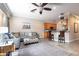 Comfortable living room with a ceiling fan, gray sofa, and tile flooring connecting to the open kitchen area at 804 Challis Pt, Longwood, FL 32779