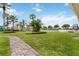 Lush backyard featuring a brick walkway, vibrant flowers, and community amenities at 822 Brunello Dr, Davenport, FL 33897