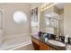 Bright bathroom with a soaking tub, dark granite countertops, vanity, and modern fixtures at 822 Brunello Dr, Davenport, FL 33897