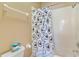 Bathroom featuring a tub with shower, mickey-themed shower curtain, and toilet with tank-top tissue at 822 Brunello Dr, Davenport, FL 33897