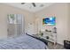 Comfortable bedroom with mounted TV, light wood floors, and sliding glass door at 822 Brunello Dr, Davenport, FL 33897
