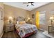 Inviting bedroom featuring light wood floors, warm lighting, a ceiling fan, and a large window at 822 Brunello Dr, Davenport, FL 33897