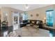 Stylish living room with a black leather sofa, modern decor, and sliding doors to the patio at 822 Brunello Dr, Davenport, FL 33897