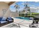 Private screened-in pool area with comfortable patio furniture and lush landscaping for ultimate relaxation at 822 Brunello Dr, Davenport, FL 33897