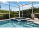 Inviting pool and spa area under a screened enclosure, surrounded by tropical foliage, offering a serene retreat at 822 Brunello Dr, Davenport, FL 33897
