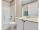 Bright bathroom featuring a shower and bathtub combo with white tile surround and a single sink vanity with white cabinets at 842 Amidon St, Deltona, FL 32725