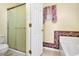Bright bathroom features a frosted glass shower, floral wallpaper border, and a decorative window valance at 842 Amidon St, Deltona, FL 32725