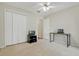 Bright bedroom featuring carpet floors, a ceiling fan, a closet, and a workspace with a TV and laptops at 842 Amidon St, Deltona, FL 32725