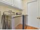 Laundry room with stainless steel washer and dryer, white cabinets above, and a white door at 842 Amidon St, Deltona, FL 32725