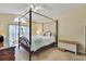 Comfortable main bedroom featuring carpet flooring, a four-poster bed, and a sunlit window at 842 Amidon St, Deltona, FL 32725