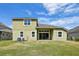 Back exterior of a two-story home featuring a covered patio and a well-maintained lawn at 8420 Corkfield Ave, Orlando, FL 32832