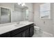 Bathroom with a large mirror, dark cabinets, and a shower with marble-look tile at 8420 Corkfield Ave, Orlando, FL 32832