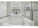 Bright bathroom featuring a soaking tub, a shower with glass doors and beautiful marble tile at 8420 Corkfield Ave, Orlando, FL 32832