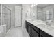 Modern bathroom featuring double sinks, granite countertops, and a glass door shower at 8420 Corkfield Ave, Orlando, FL 32832