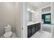Bathroom with dual sinks, granite counters, and toilet with adjacent bedroom view at 8420 Corkfield Ave, Orlando, FL 32832