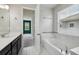 Bathroom with garden tub, marble tiling, and vanity with white countertop at 8420 Corkfield Ave, Orlando, FL 32832