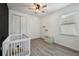 Cozy Bedroom with wood-look floors, a window, and a white crib at 8420 Corkfield Ave, Orlando, FL 32832