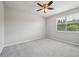 Neutral bedroom featuring a ceiling fan, window, and carpet flooring at 8420 Corkfield Ave, Orlando, FL 32832
