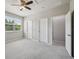 Bedroom featuring plush carpet, a ceiling fan, and two closets at 8420 Corkfield Ave, Orlando, FL 32832