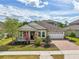 Charming home with a well-manicured lawn, a brick driveway, and a 2-car garage at 8420 Corkfield Ave, Orlando, FL 32832