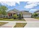 Charming single-Gathering home featuring a well-manicured lawn, brick-paved driveway and lush, colorful landscaping at 8420 Corkfield Ave, Orlando, FL 32832