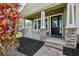 Close-up of the front porch featuring stone columns, a black front door, and lush landscaping elements at 8420 Corkfield Ave, Orlando, FL 32832