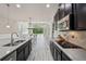 Modern kitchen with black cabinets, stainless steel appliances, and views into eat in space at 8420 Corkfield Ave, Orlando, FL 32832
