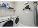 Neat laundry area with modern washer and dryer units and storage shelving at 8420 Corkfield Ave, Orlando, FL 32832