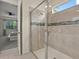Modern bathroom with a glass-enclosed shower, tiled walls, and a window for natural light at 8943 Coconut Breeze Dr, Kissimmee, FL 34747