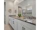 Bright bathroom featuring a double vanity with granite countertops and a glass-enclosed shower at 8943 Coconut Breeze Dr, Kissimmee, FL 34747