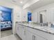 Bathroom featuring granite countertops, double vanity, and a peek into the -themed bedroom at 8943 Coconut Breeze Dr, Kissimmee, FL 34747