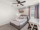 Comfortable bedroom featuring a queen-sized bed, a desk, and neutral decor at 8943 Coconut Breeze Dr, Kissimmee, FL 34747