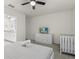 Neutral bedroom featuring ceiling fan, television, and a baby crib for convenience at 8943 Coconut Breeze Dr, Kissimmee, FL 34747