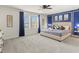Spacious bedroom with a king-sized bed, blue accent wall, and bright natural light at 8943 Coconut Breeze Dr, Kissimmee, FL 34747