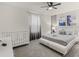 Bedroom with a crib, a queen bed, and soft neutral colors at 8943 Coconut Breeze Dr, Kissimmee, FL 34747