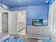 Stylish bedroom with TV, blue wall and an ensuite bathroom with a granite vanity at 8943 Coconut Breeze Dr, Kissimmee, FL 34747