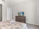 Bright bedroom featuring a dresser with a TV on it, with access to the en-suite bathroom at 8943 Coconut Breeze Dr, Kissimmee, FL 34747