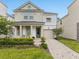 Charming two-story home featuring a well-maintained lawn and a beautiful brick driveway leading to an attached garage at 8943 Coconut Breeze Dr, Kissimmee, FL 34747