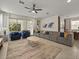 Expansive living room with stylish furniture, large windows, and seamless flow into the dining and kitchen areas at 8943 Coconut Breeze Dr, Kissimmee, FL 34747