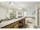 Bright bathroom featuring double sinks, granite countertops, soaking tub, and a glass shower stall at 8989 Cuban Palm Rd, Kissimmee, FL 34747