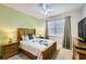Cozy bedroom with a queen-size bed, a ceiling fan, and natural light from the window at 8989 Cuban Palm Rd, Kissimmee, FL 34747