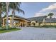 Clubhouse exterior featuring a grand entrance, manicured landscaping, and a circular driveway at 8989 Cuban Palm Rd, Kissimmee, FL 34747