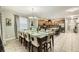 Open dining and kitchen area featuring stainless appliances, granite counters, and a large dining table at 8989 Cuban Palm Rd, Kissimmee, FL 34747
