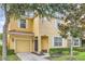 Inviting two-story home with a yellow exterior, white trim, covered entry, and attached garage at 8989 Cuban Palm Rd, Kissimmee, FL 34747