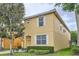 Two story home boasts a yellow exterior, white trim, and a well-manicured lawn at 8989 Cuban Palm Rd, Kissimmee, FL 34747