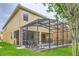 Exterior shot of a two-story home with a screened in pool and an outdoor patio overlooking a well-manicured lawn at 8989 Cuban Palm Rd, Kissimmee, FL 34747