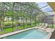 Backyard pool features lush landscaping, lounge chairs and is surrounded by a screened enclosure at 8989 Cuban Palm Rd, Kissimmee, FL 34747