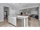 Spacious kitchen featuring white cabinets, quartz countertops, and stainless steel appliances, with open floorplan at 9262 Sw 58Th Cir, Ocala, FL 34476