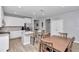 Open kitchen with white cabinetry, stainless appliances, seating at the island, and a dining table nearby at 9262 Sw 58Th Cir, Ocala, FL 34476