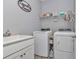 Functional laundry room featuring a sink, washer, dryer, and ample storage space for supplies at 9262 Sw 58Th Cir, Ocala, FL 34476